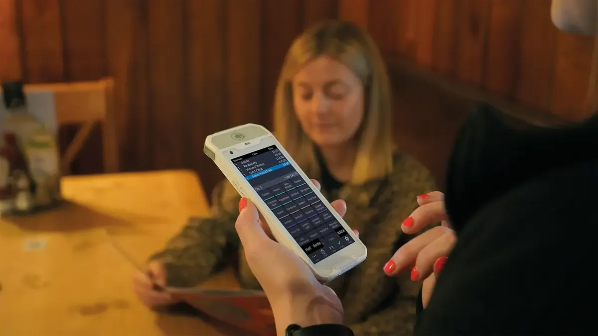 Paying at the table on a handheld card machine in a pub